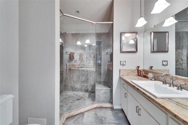 bathroom featuring vanity, toilet, and a shower with shower door