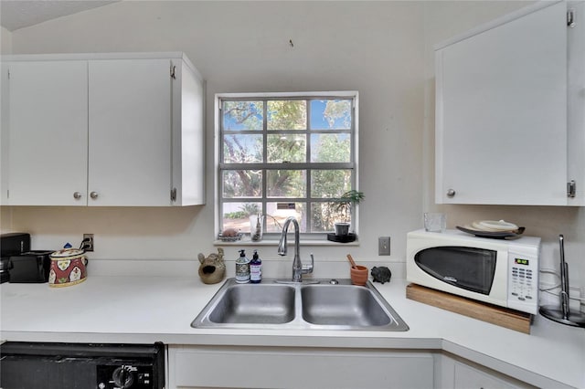 kitchen with dishwashing machine, sink, a wealth of natural light, and white cabinets