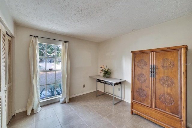 doorway to outside with light tile patterned flooring and a textured ceiling