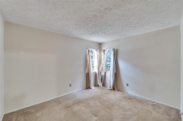 carpeted empty room featuring a textured ceiling