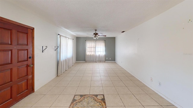 tiled empty room with a textured ceiling and ceiling fan