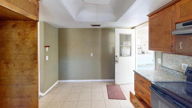 kitchen with backsplash, electric range, light stone countertops, light tile patterned floors, and washer / clothes dryer