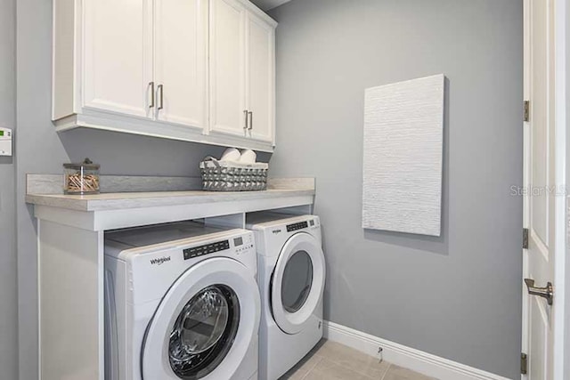 laundry room with cabinets, independent washer and dryer, and light tile patterned floors