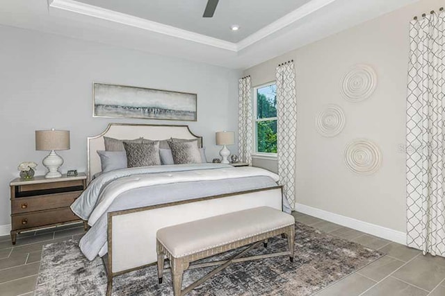 tiled bedroom with ceiling fan and a raised ceiling