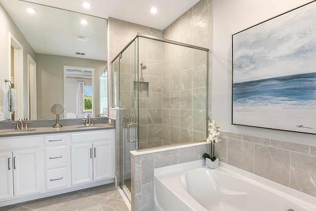 bathroom featuring vanity and independent shower and bath