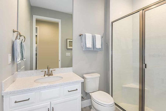 bathroom featuring vanity, an enclosed shower, and toilet