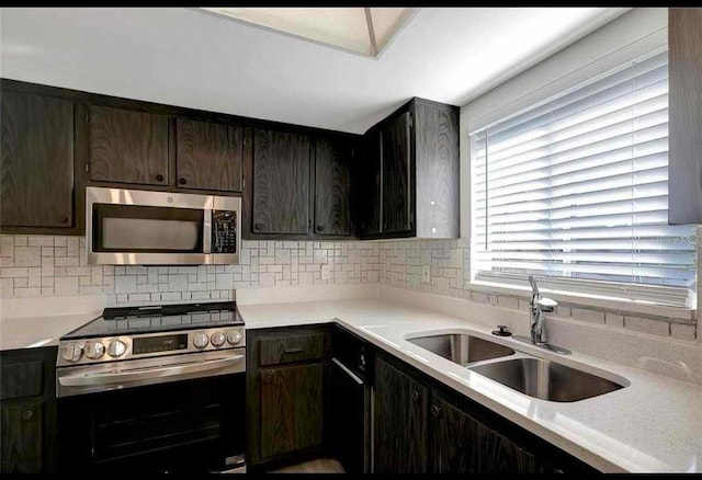 kitchen featuring dark brown cabinets, sink, appliances with stainless steel finishes, and tasteful backsplash