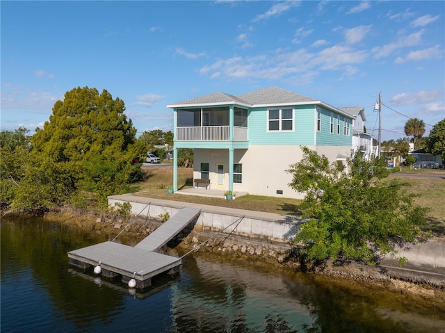 back of house featuring a sunroom, a water view, and a patio