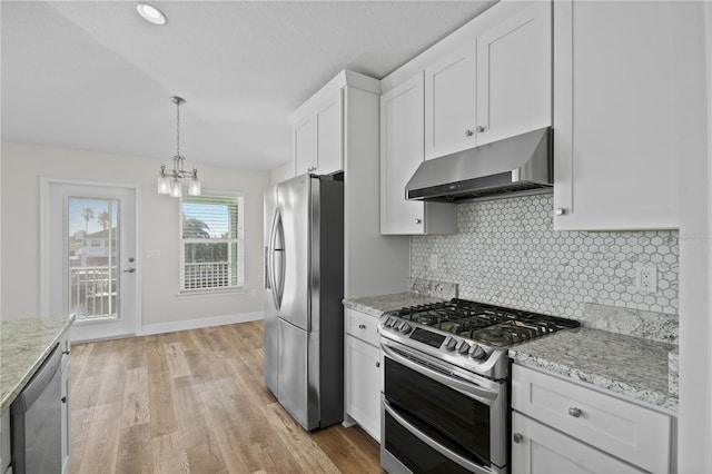 kitchen featuring white cabinets, hanging light fixtures, light hardwood / wood-style flooring, light stone countertops, and appliances with stainless steel finishes