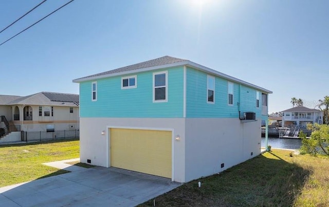 view of home's exterior featuring a yard, a water view, and a garage