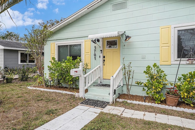 property entrance with a lawn