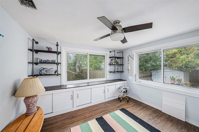 living area featuring dark wood-type flooring and ceiling fan