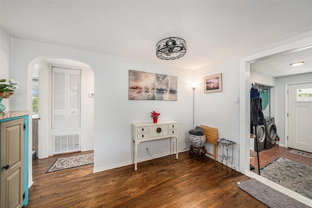 interior space with dark hardwood / wood-style flooring, a textured ceiling, and independent washer and dryer