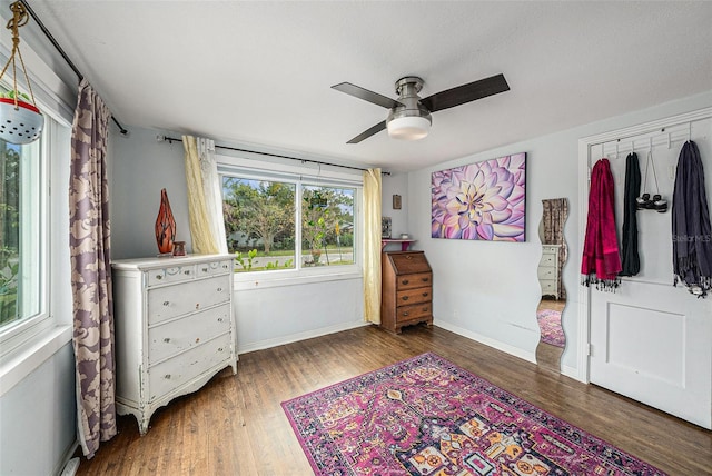 bedroom featuring multiple windows, dark hardwood / wood-style floors, and ceiling fan