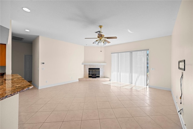 unfurnished living room with ceiling fan, light tile patterned floors, and a textured ceiling