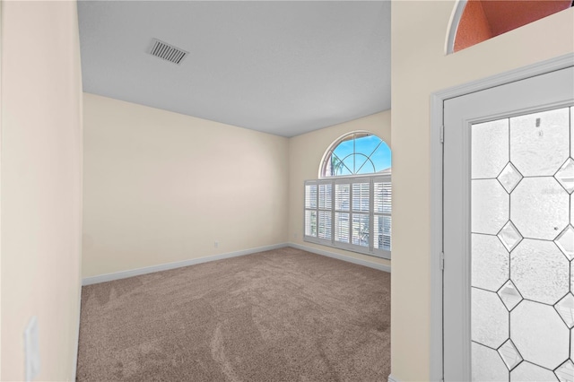 carpeted empty room with visible vents and baseboards