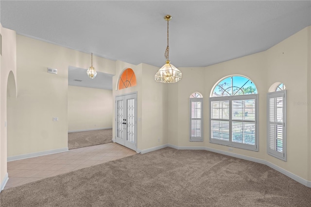 tiled empty room with carpet flooring, baseboards, visible vents, and french doors