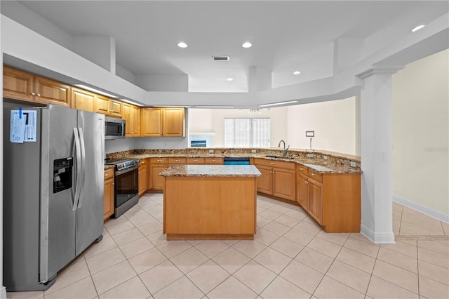 kitchen featuring visible vents, light stone counters, a center island, stainless steel appliances, and light tile patterned flooring