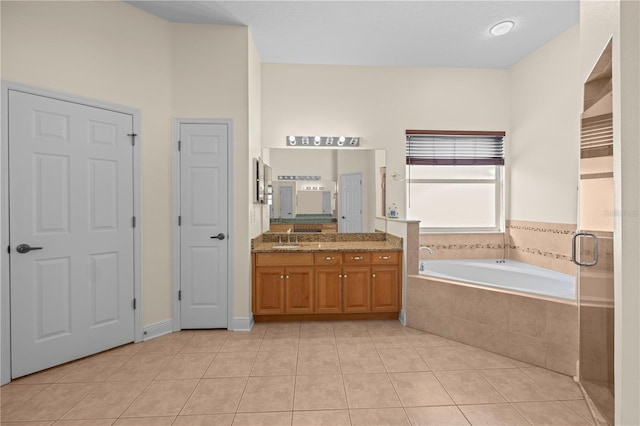 bathroom featuring tile patterned flooring, vanity, and a garden tub