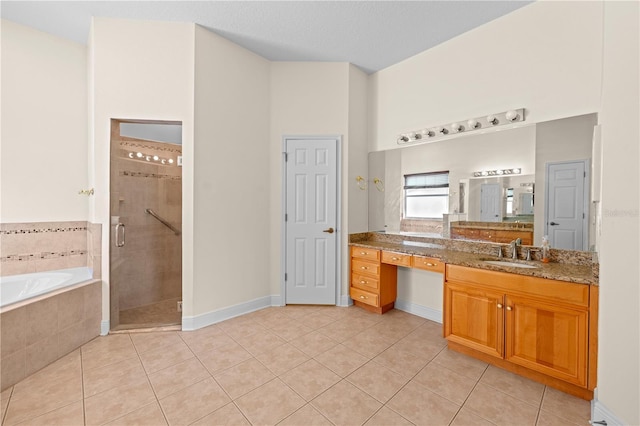 bathroom with a shower stall, tile patterned flooring, baseboards, a bath, and vanity