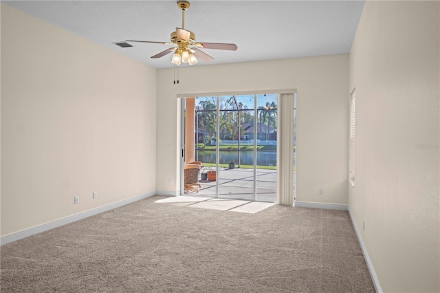 carpeted spare room featuring visible vents, ceiling fan, and baseboards