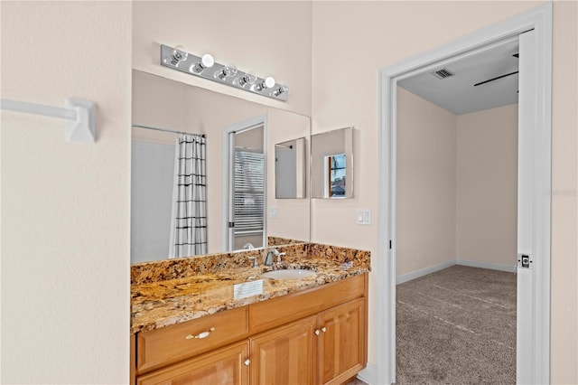 bathroom with visible vents, baseboards, curtained shower, and vanity