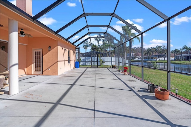 exterior space with a lanai, a residential view, ceiling fan, and a water view