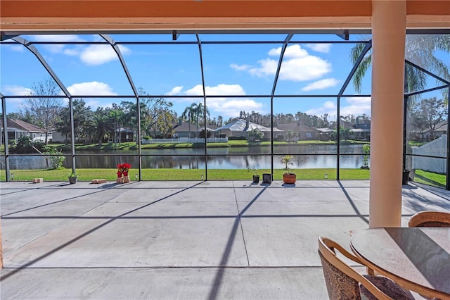 exterior space featuring a water view, a lanai, a residential view, a lawn, and a patio