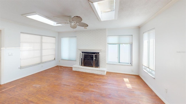 unfurnished living room with hardwood / wood-style floors, ceiling fan, a textured ceiling, and a skylight