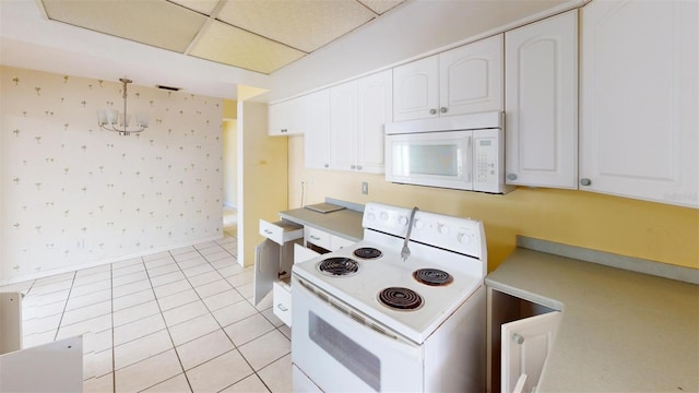 kitchen with light tile patterned floors, white cabinets, and white appliances