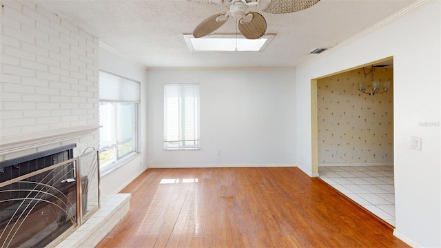 unfurnished living room featuring a fireplace, a textured ceiling, and ornamental molding