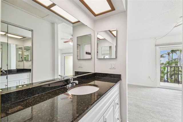 bathroom featuring ceiling fan, vanity, and baseboards