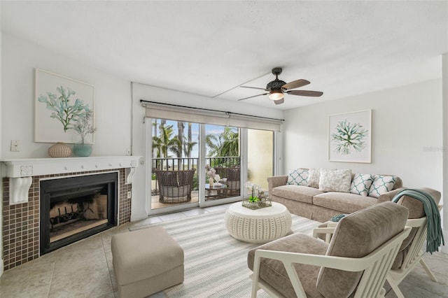 living area with a tiled fireplace and a ceiling fan