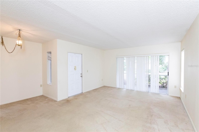 carpeted spare room with a textured ceiling