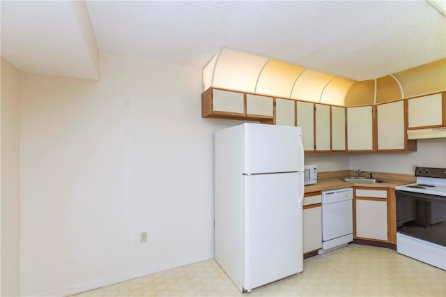 kitchen featuring a textured ceiling, white appliances, and sink