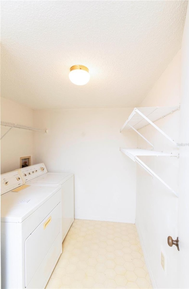 laundry room with washing machine and dryer and a textured ceiling