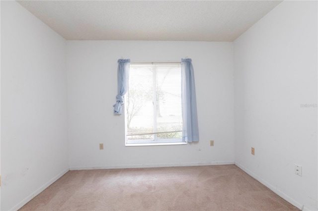 spare room featuring light colored carpet