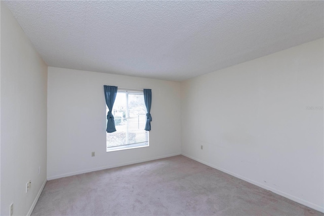 empty room featuring light carpet and a textured ceiling