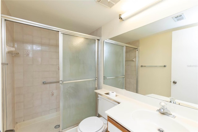 bathroom with vanity, toilet, and a shower with door