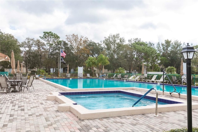 view of pool with a patio and a hot tub