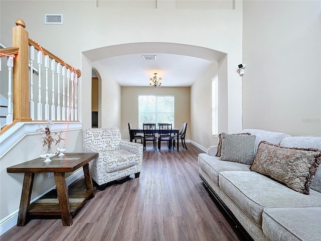 living room featuring wood-type flooring and an inviting chandelier