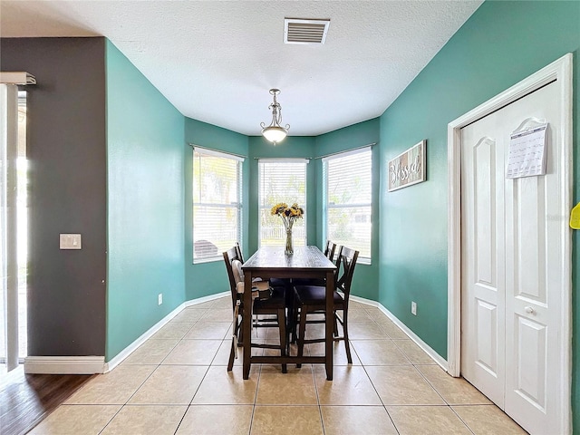 tiled dining room with a textured ceiling