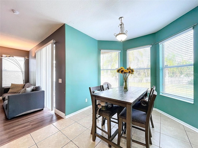 dining area featuring plenty of natural light, light tile patterned floors, and a textured ceiling