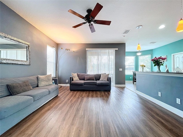 living room featuring a textured ceiling, hardwood / wood-style flooring, and ceiling fan