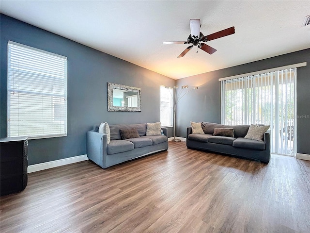 living room with hardwood / wood-style flooring, a wealth of natural light, and ceiling fan