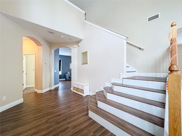 stairs with hardwood / wood-style flooring and crown molding