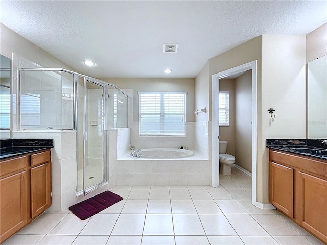 full bathroom with a textured ceiling, vanity, plus walk in shower, tile patterned flooring, and toilet