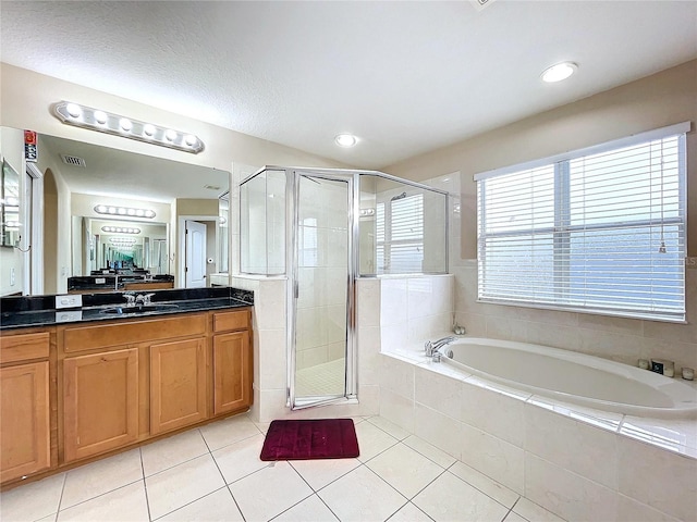 bathroom with tile patterned flooring, vanity, and plus walk in shower