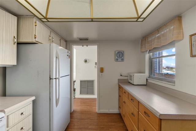 kitchen with white appliances and light hardwood / wood-style flooring