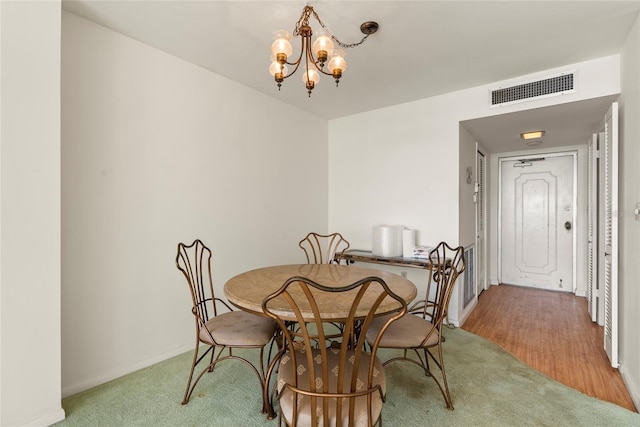 dining room featuring carpet flooring and a chandelier